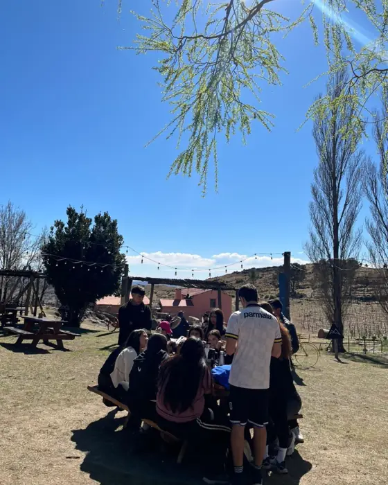 El grupo come al aire libre en una mesa de campo.